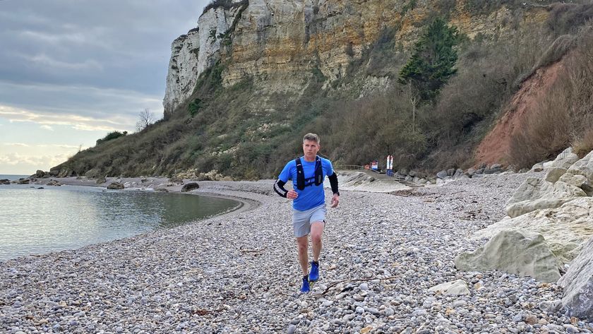  Man running on the beach wearing a hydration vest