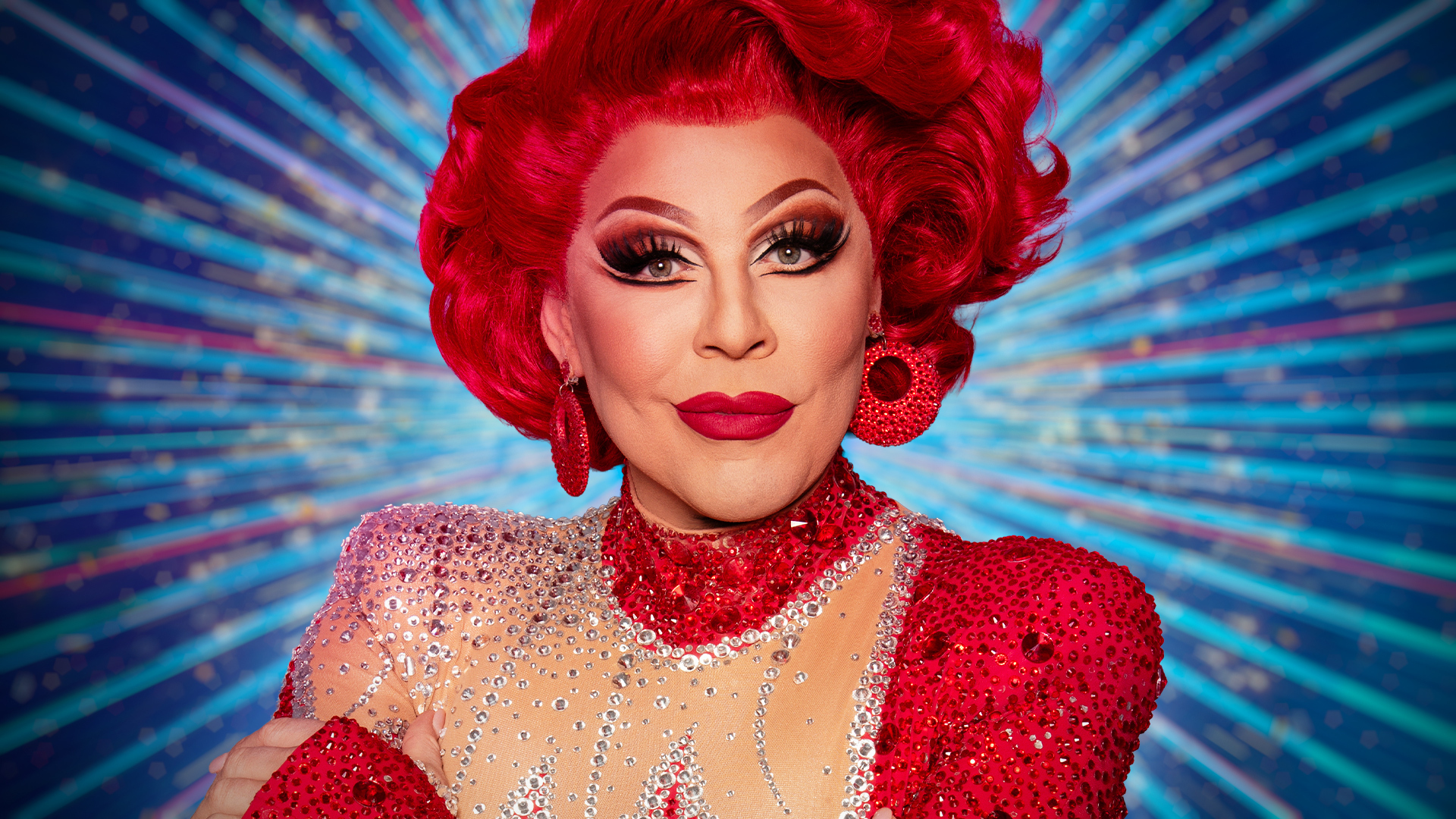 La Voix smiling for the camera with a blue sparkly background behind her.