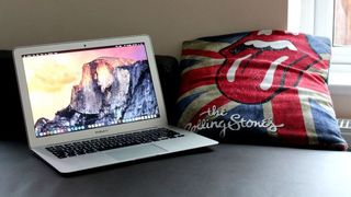 Laptop computer next to Rolling Stones pillow