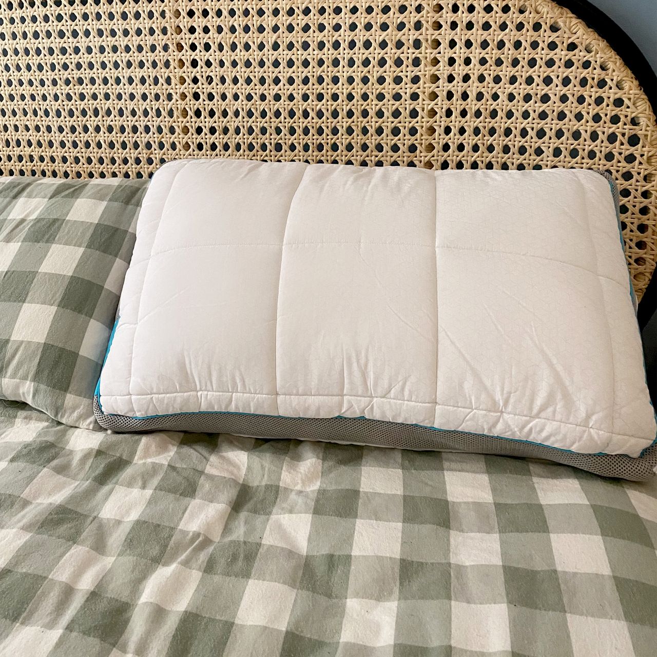 The Simba Hybrid Firm pillow being tested on a bed with a green and white checked duvet