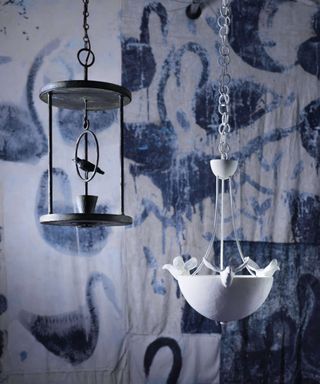 Bird pendant lights by Porta Romana in front of blue and white wallpaper