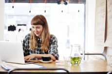 Woman working on laptop in coffee shop