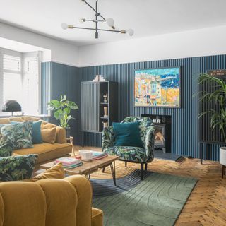 Living room with blue panelling and mustard yellow sofa and chairs