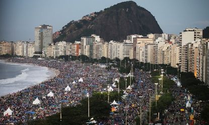 Pilgrims and residents camp out on Copacabana Beach at dawn while awaiting Pope Francis' final Mass on his trip to Brazil on July 28, 2013 in Rio de Janeiro, Brazil. A reported crowd of three