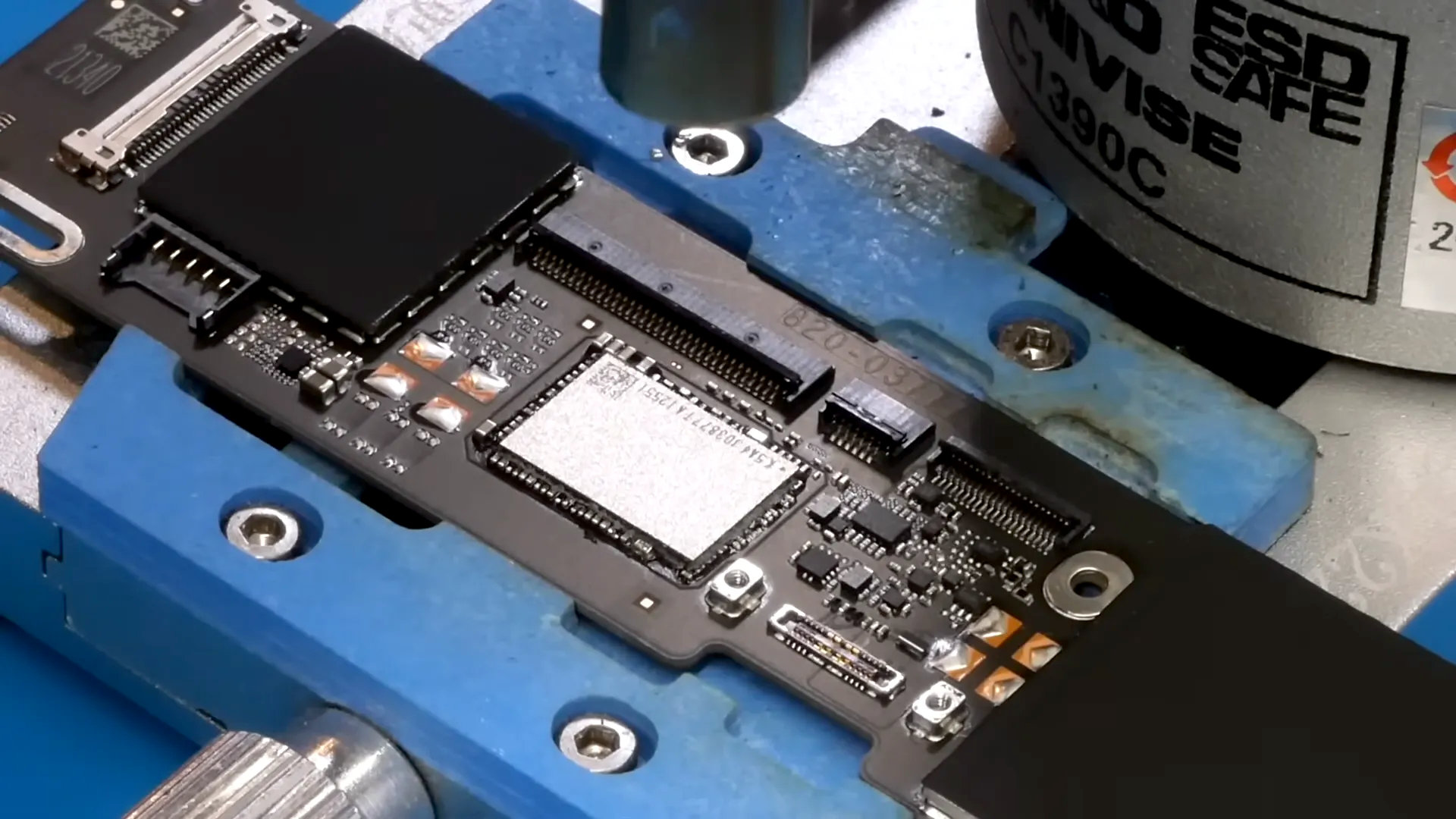 A screenshot of a YouTube video by dosdude1, in which they replace the 256 GB flash chip in a MacBook Neo with a 1 TB module