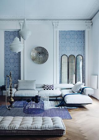 Blue color-drenched living room with paneled wallpaper