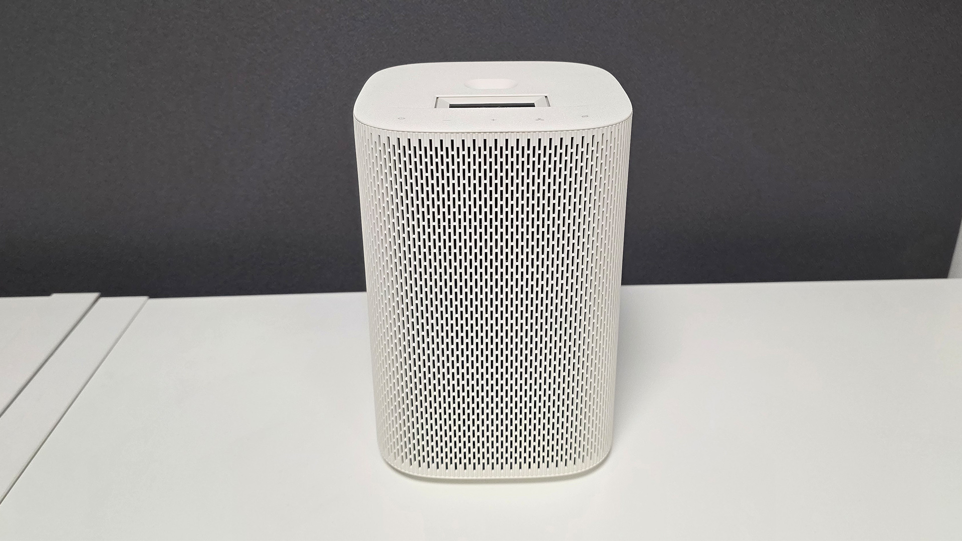 Samsung The Premiere 5 ultra short throw projector on white surface against dark background