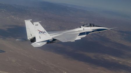 a white-and-blue fighter jet soars through the sky