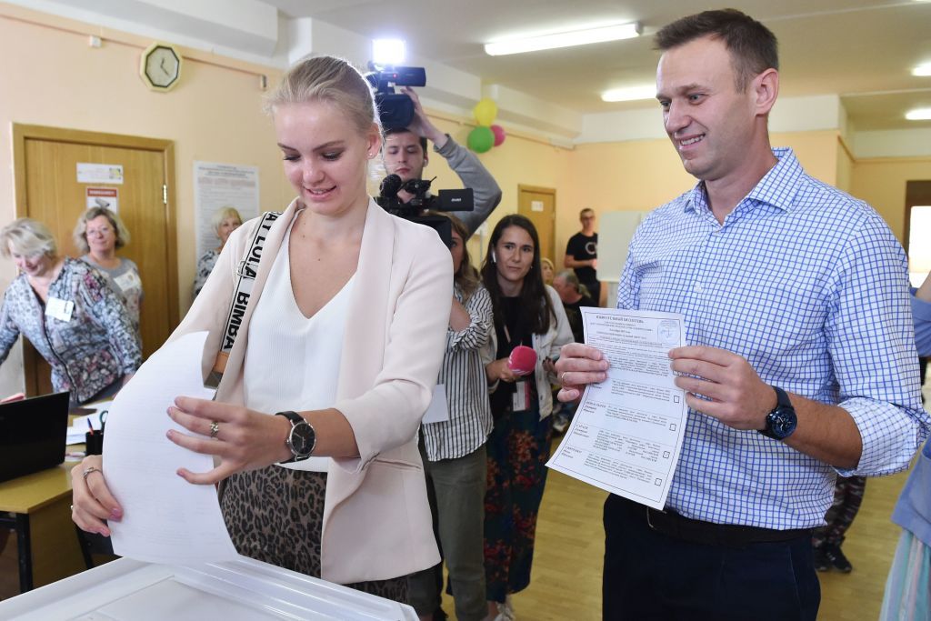 Russian opposition activist Alexei Navalny looks on as his daughter Daria casts her vote at a polling station in Moscow.