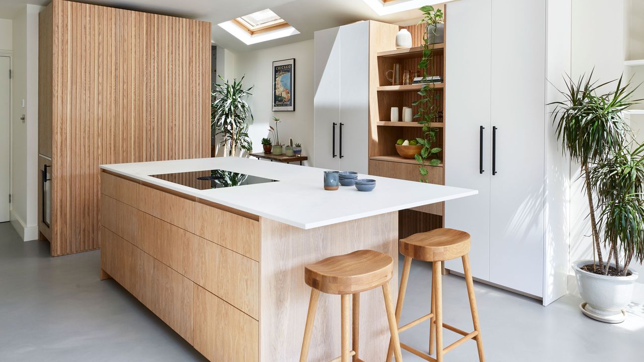 Wooden kitchen with white countertop and wooden stools