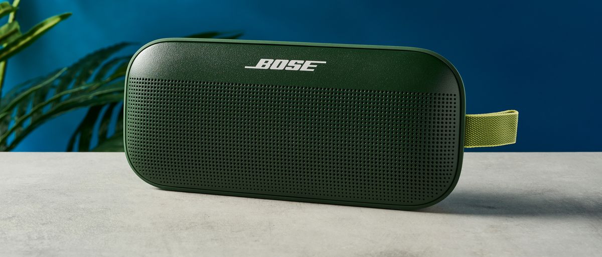 a green bluetooth speaker made by bose with a clean plastic casing and no visible woofers rests on a table