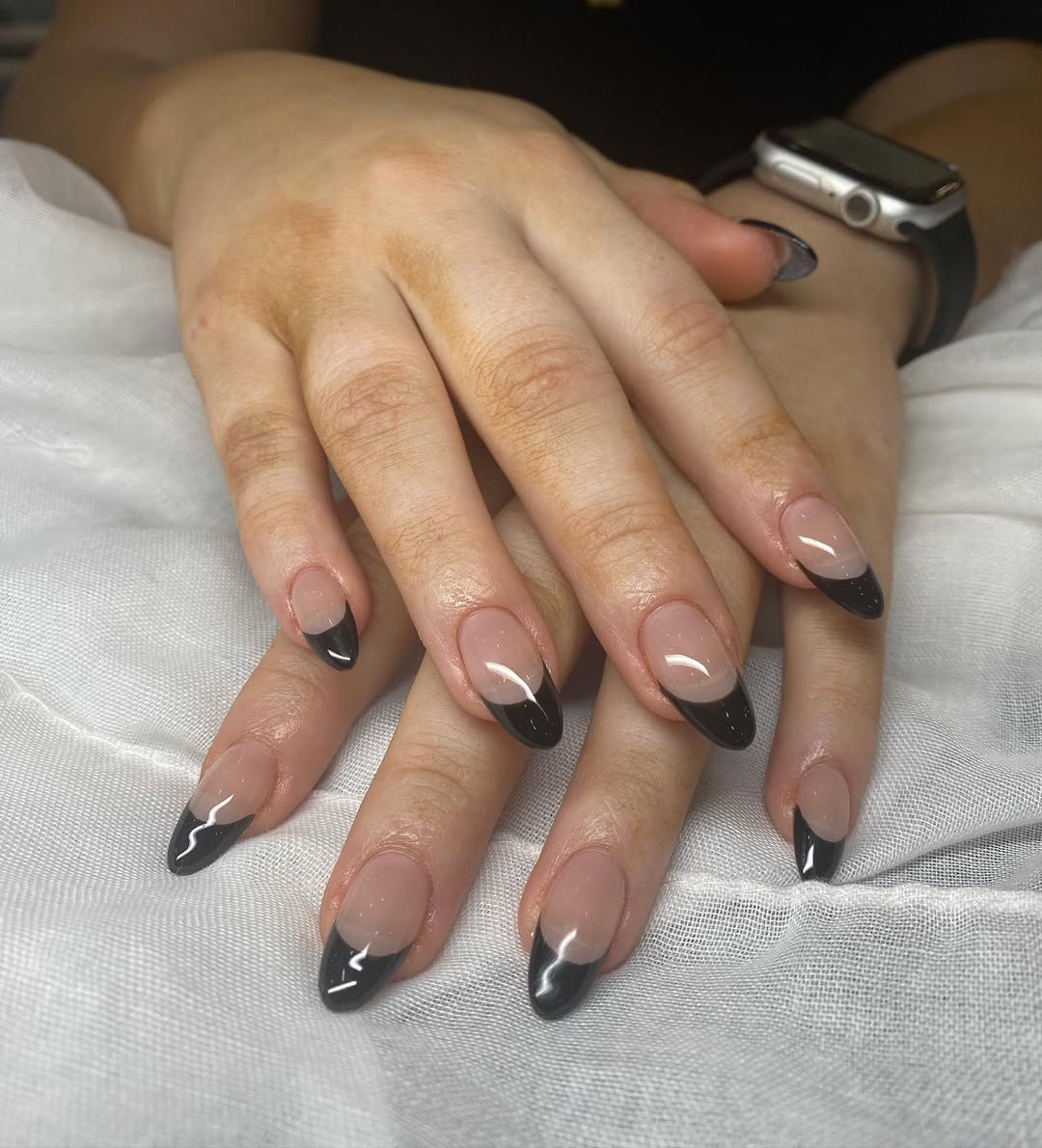 a person wearing a black french manicure