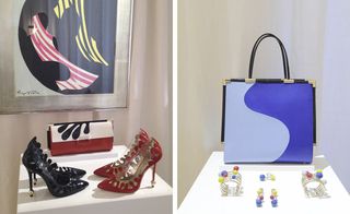 Two images. Left: A pair of black and red stiletto shoes, with red, cream and black design clutch bag on a white viewing platform, white walls, picture frame on wall. Right: white walls, blue design handbag, custom made jewellery pieces displayed on a white viewing platform