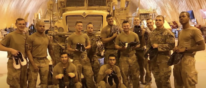 Soldiers hold up their new shoes.