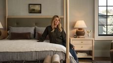 designer shea mcgee sat on a light oak four poster bed styled for fall