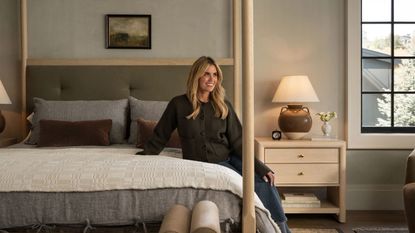 designer shea mcgee sat on a light oak four poster bed styled for fall