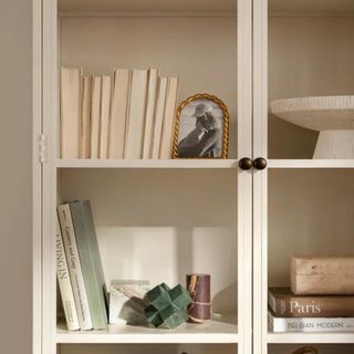 White shelving with books, a picture frame and decorative objects from McGee & Co.