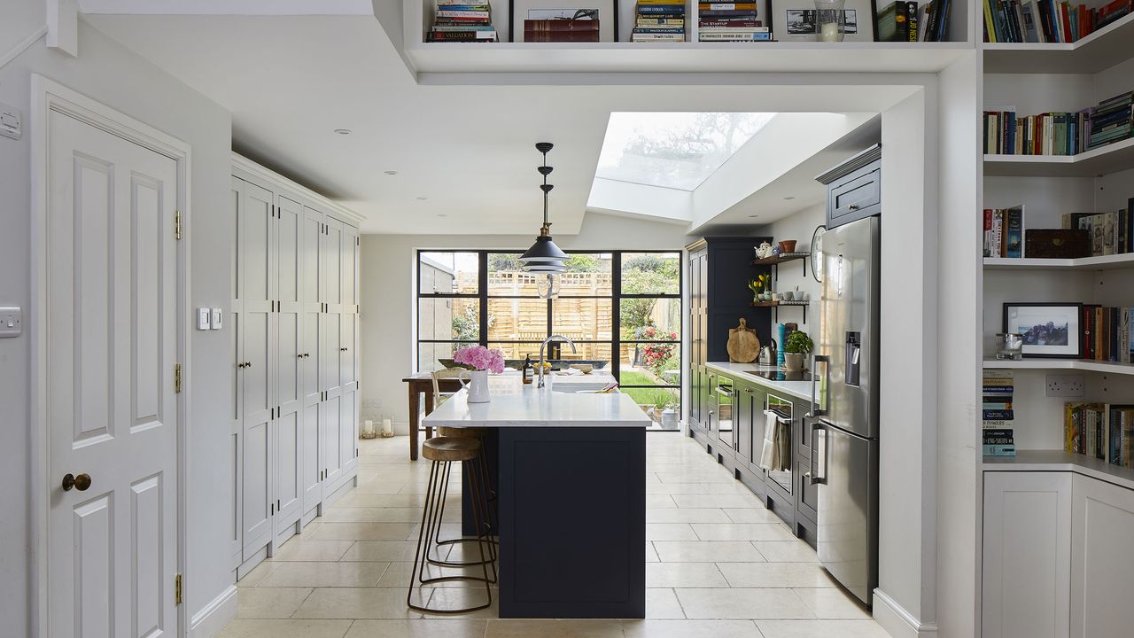 open-plan bright white kitchen diner with glazed doors and statement island