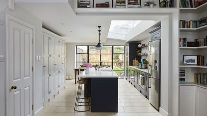 open-plan bright white kitchen diner with glazed doors and statement island