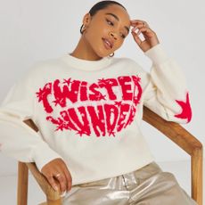 Model sat in a chair wearing Simply Be x Twisted Wunder