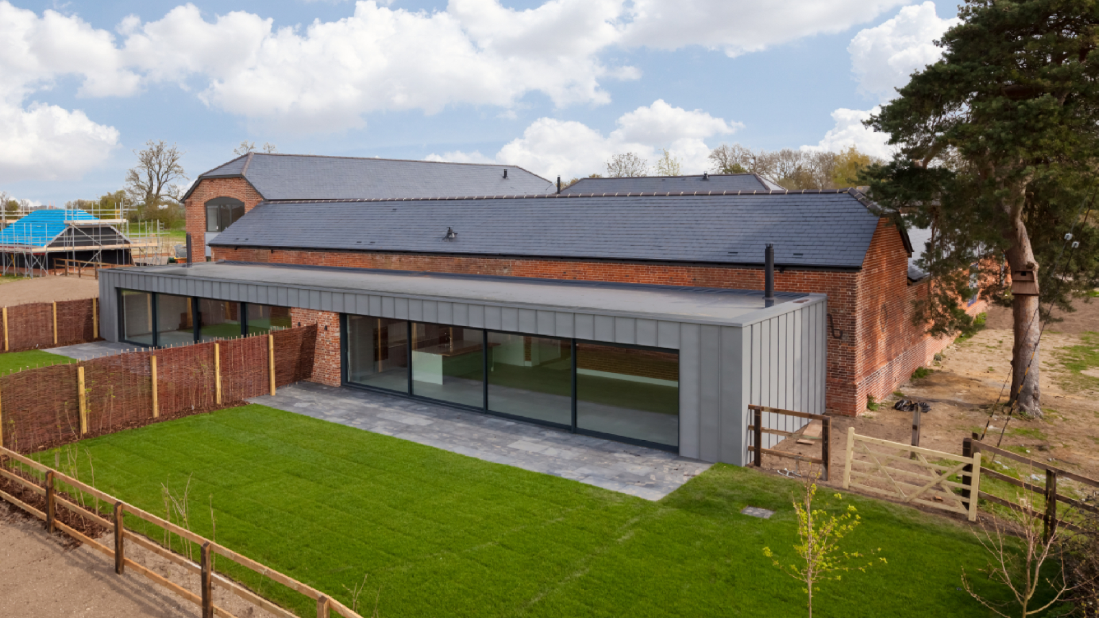 barn conversion with modern zinc clad flat roof extension on front
