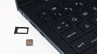 SIM card with tray beside a laptop