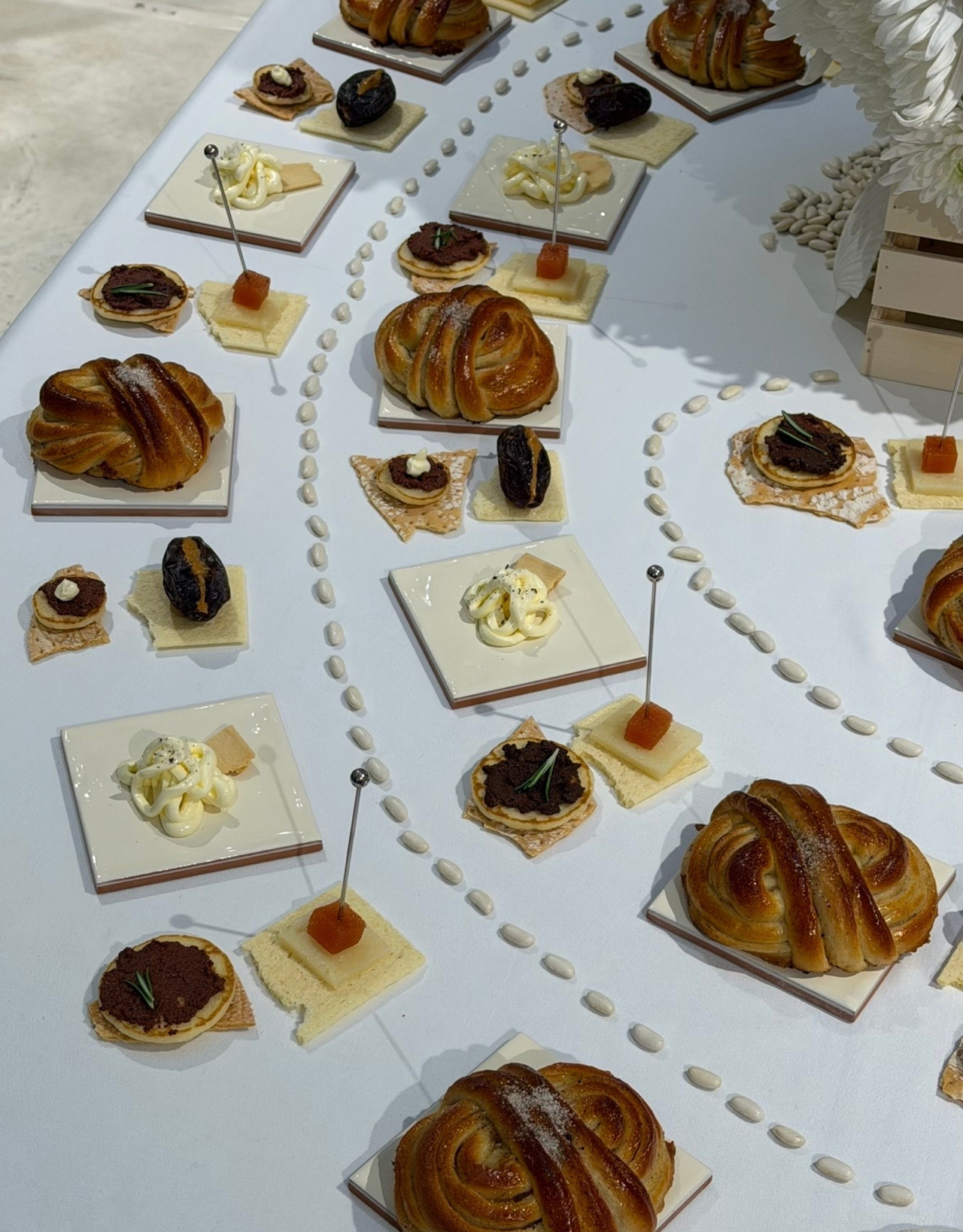 a food isntallation of pastries and squiggles of butter on ceramic slabs
