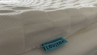 A closeup of the Levitex Gravity Defying mattress topper tag