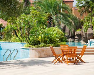 pool with tropical planting and table and chairs