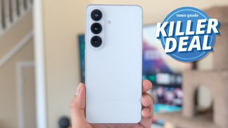 Galaxy S26 held in the hand with killer deal badge nearby.