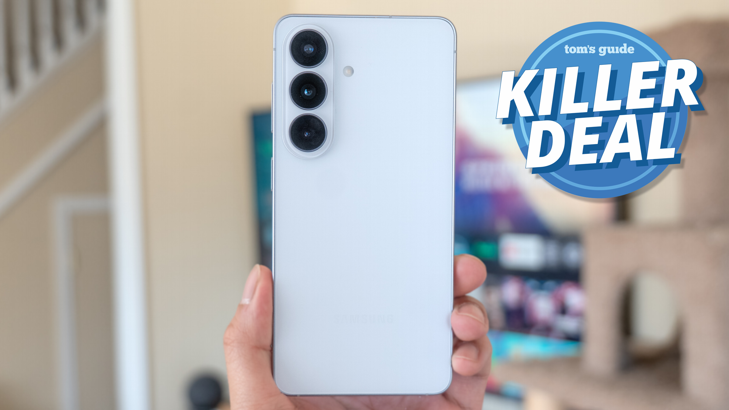 Galaxy S26 held in the hand with killer deal badge nearby.