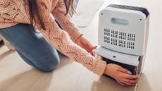 Is dehumidifier water safe to drink? image shows woman emptying a dehumidifier