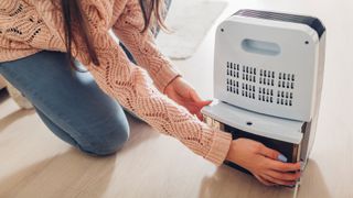 Woman emptying a dehumidifier