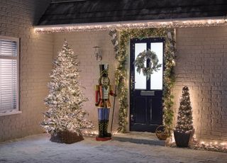 christmas lighting ideas with front door wreath and giant nutcracker