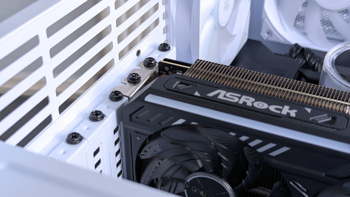 Close-up of an ASRock graphics card installed in an iBUYPOWER RDY Trace X R01 computer case. The interior shows cooling fans and detailed hardware components.