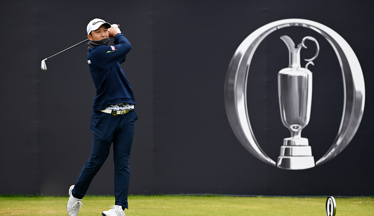 Aguri Iwasaki strikes a tee shot in front of an Open Championship banner