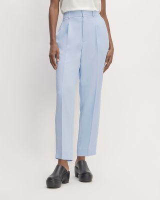 a model wears light blue trousers with black clogs