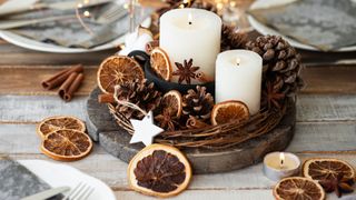 Christmas centerpiece idea with wooden plate with candles and orange slices