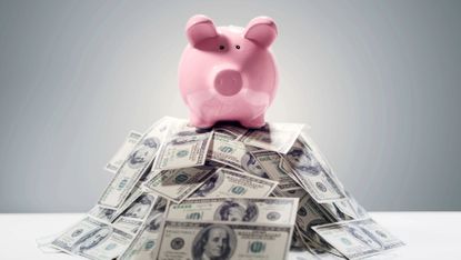 Piggy bank on big pile of dollars 