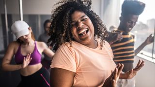 A woman loving life dancing in a group class at the gym