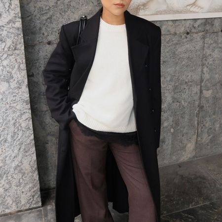 Woman in white sweater and black coat