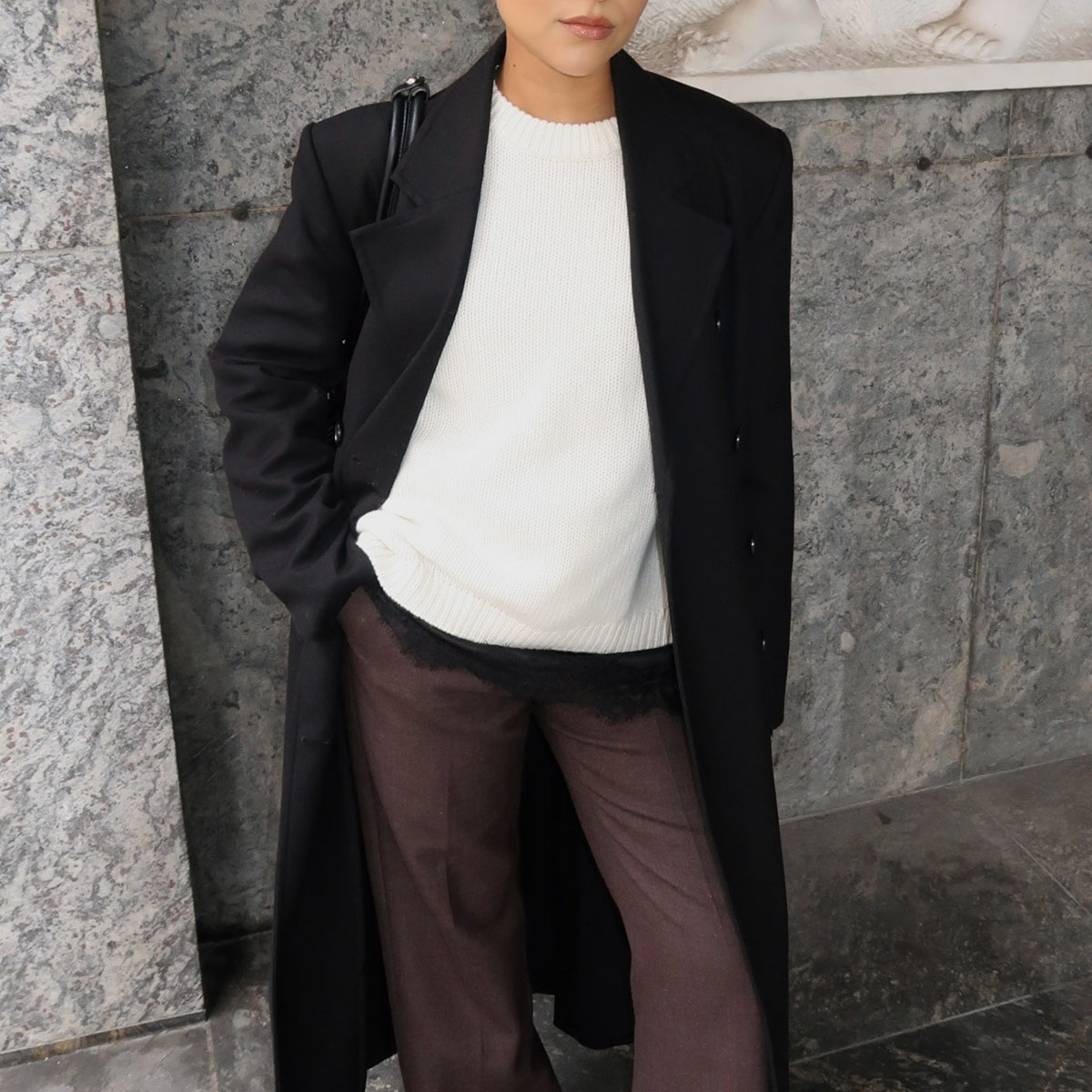 Woman in white sweater and black coat