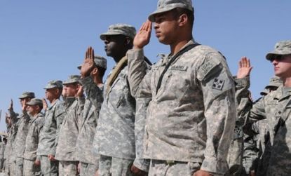 Soldiers stand in salute in Afghanistan: though bin Laden's decade-long terrorism didn't completely bankrupt the U.S. the wars have been costing trillions.