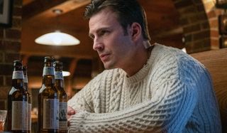 Chris Evans wears "the sweater" with a couple of beers on the table in Knives Out.