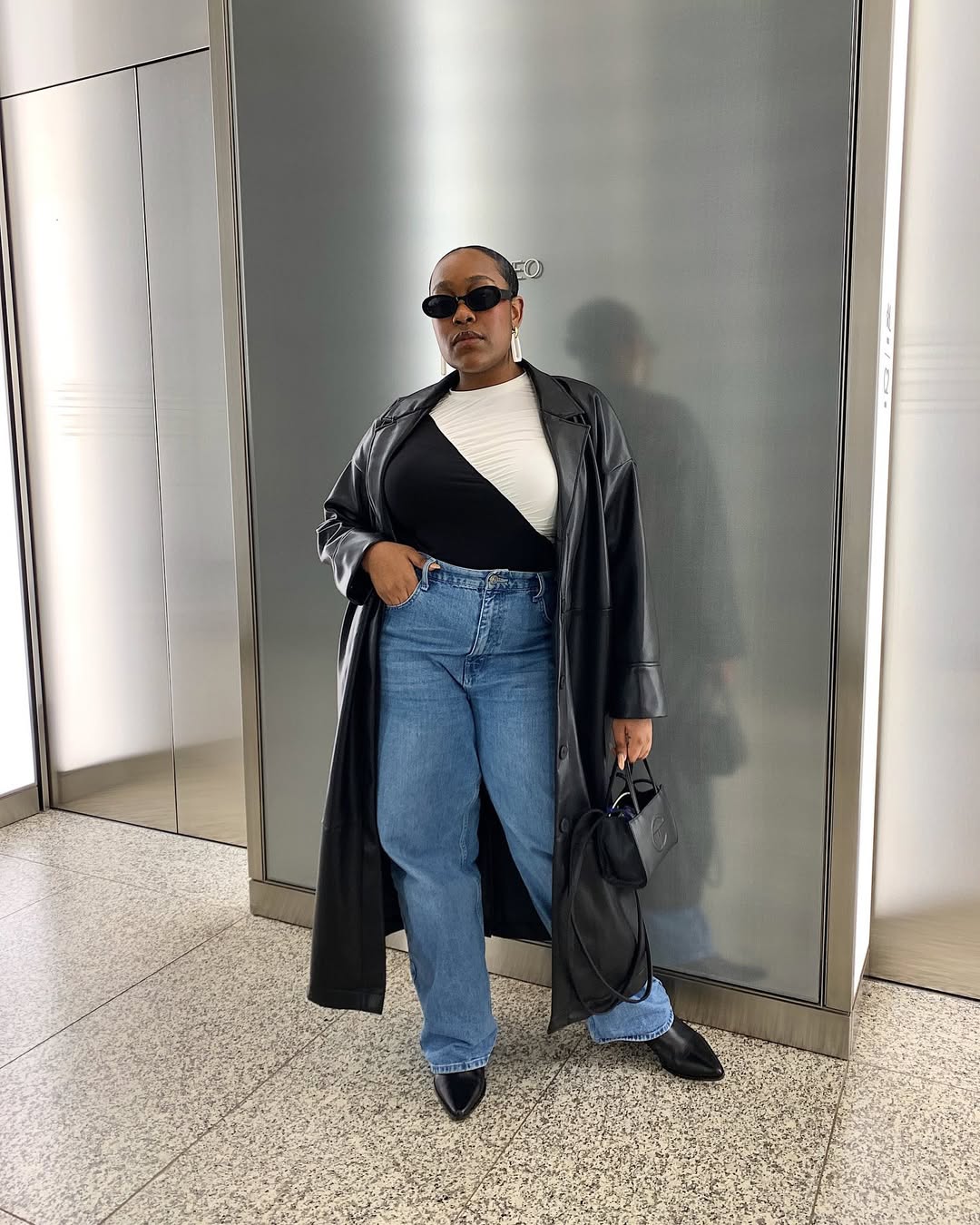 woman wearing slim jeans with leather trench coat