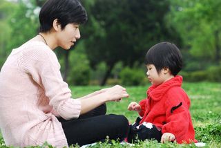 mother with her daughter playing on grass 