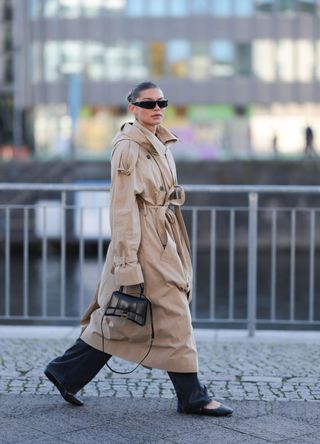 Sophia Geiss wearing a trench coat, wide leg jeans and black ballet flats