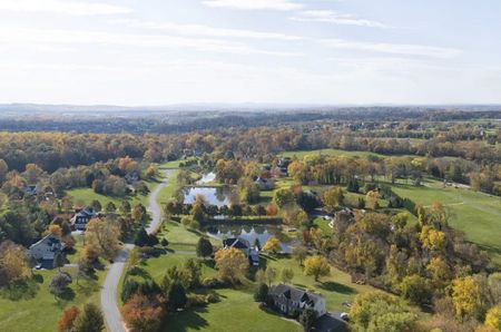 An aerial view of a road through scenic western Loudoun County, Virginia, in autumn with the leaves starting to change colours