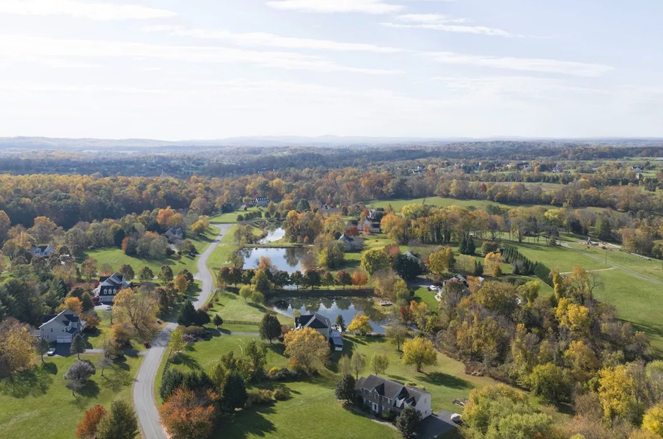 An aerial view of a road through scenic western Loudoun County, Virginia, in autumn with the leaves starting to change colours