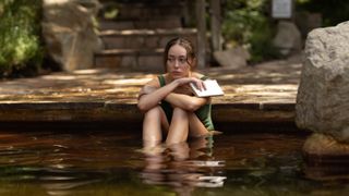 Milla Blake (Alycia Debnam-Carey) sits in a pond in Netflix's "Apple Cider Vinegar"